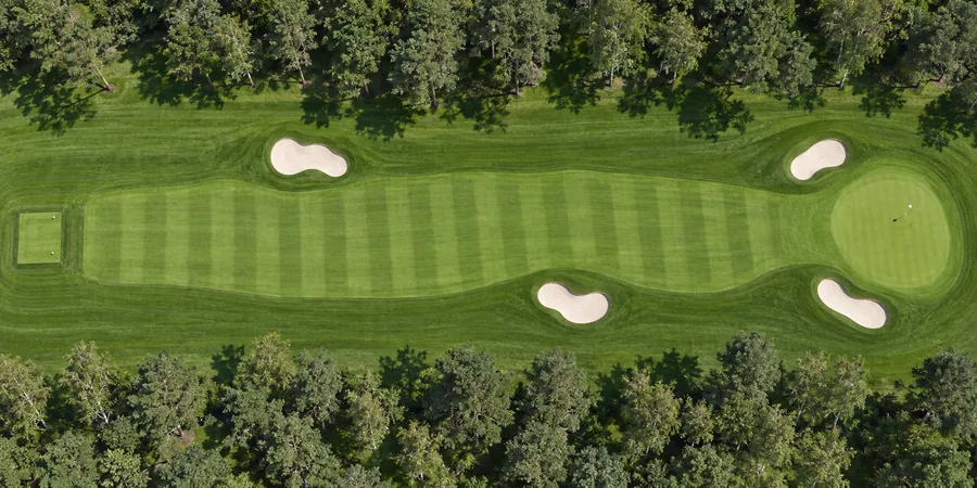 Aerial view of hole 18, Clubhouse, from the tee on the left to the green on the right.